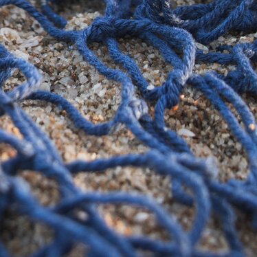 Plastikmüll in einem Fischernetz am Strand