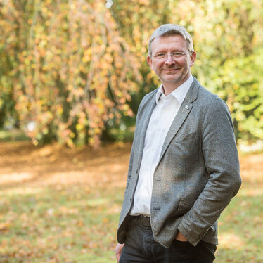 Umweltpastor Christoph Fasse im Porträt Umweltpastor Christoph Fasse im Porträt in einem Wald bei Sonne