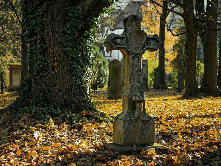 Grabstein im Herbst auf einem Friedhof