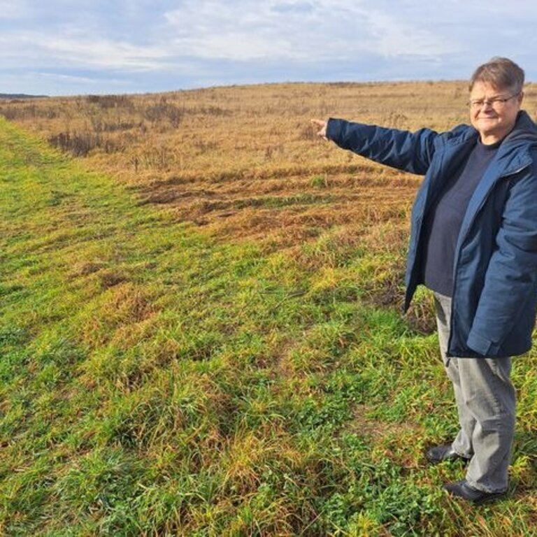 Christine Jantzen, Ehrenamtliche Bürgermeisterin von Kieve zeigt auf den Acker für die PV-Anlage