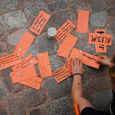 Hände legen Workshopkarten auf dem Boden aus. Ein Beispiel für einen Kreativen Workshop, bei dem man als Kirche beim Klimaschutz aktiv sein