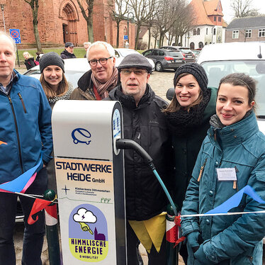 Das Team der Ökumensichen Arbeitsstelle im Kirchenkreis Dithmarschen vor Ladesäule.